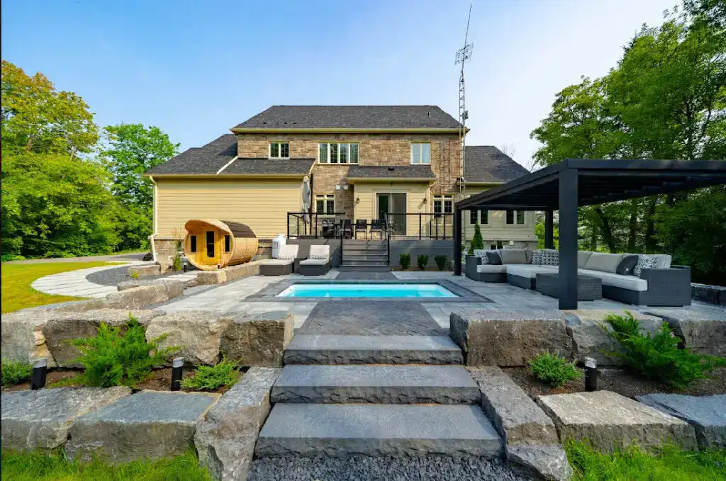 A stunning backyard featuring a swimming pool, outdoor seating, and beautiful landscaping for relaxation and entertainment.