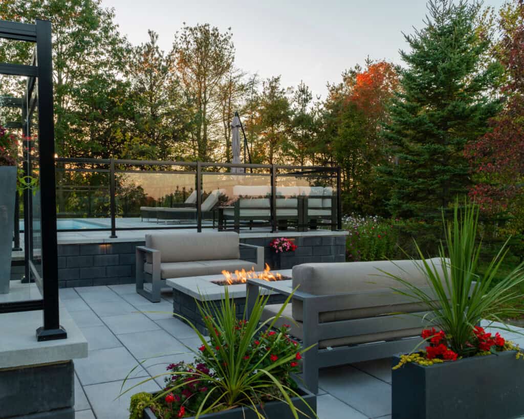 Beautiful landscaped backyard with firepit, modern patio, and vibrant autumn trees.